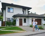 Rodzina przed nowoczesnym domem. Zastanawiasz się, ile realnie kosztuje budowa domu?