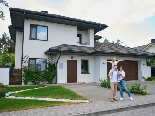 Rodzina przed nowoczesnym domem. Zastanawiasz się, ile realnie kosztuje budowa domu?
